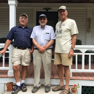 Three men on the porch.